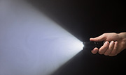 hand holding a flashlight in the dark