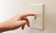 hand turning off light switch